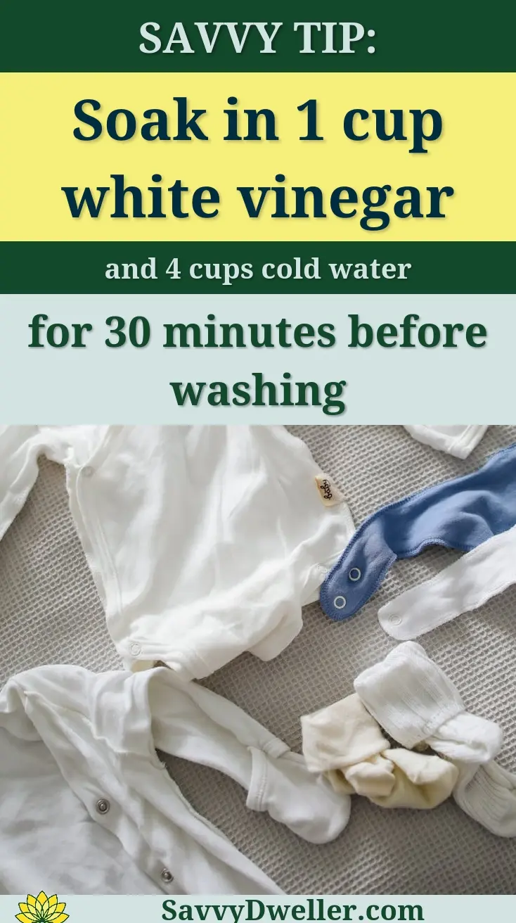 From above of cute cotton suits bibs socks and hats for little babies on gray bedspread on bed at home on daytime on gray