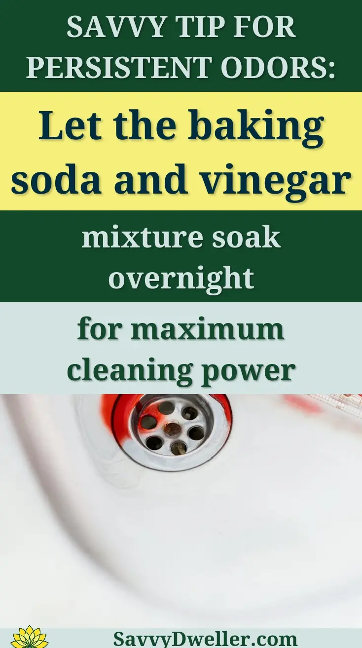 A close-up of red liquid spilling from a pipette into a stainless steel sink drain.