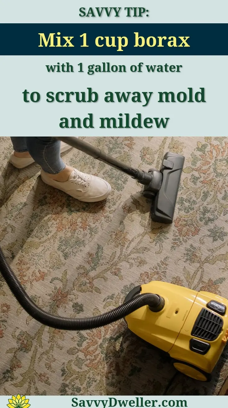 Person cleaning a floral carpet with a yellow vacuum cleaner indoors.