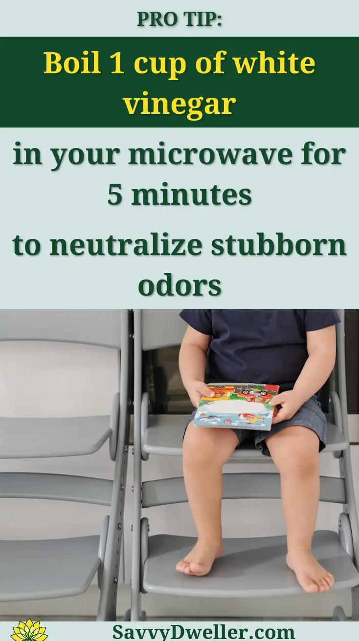 Adorable child with children's book sitting on chairs in a modern kitchen setting.