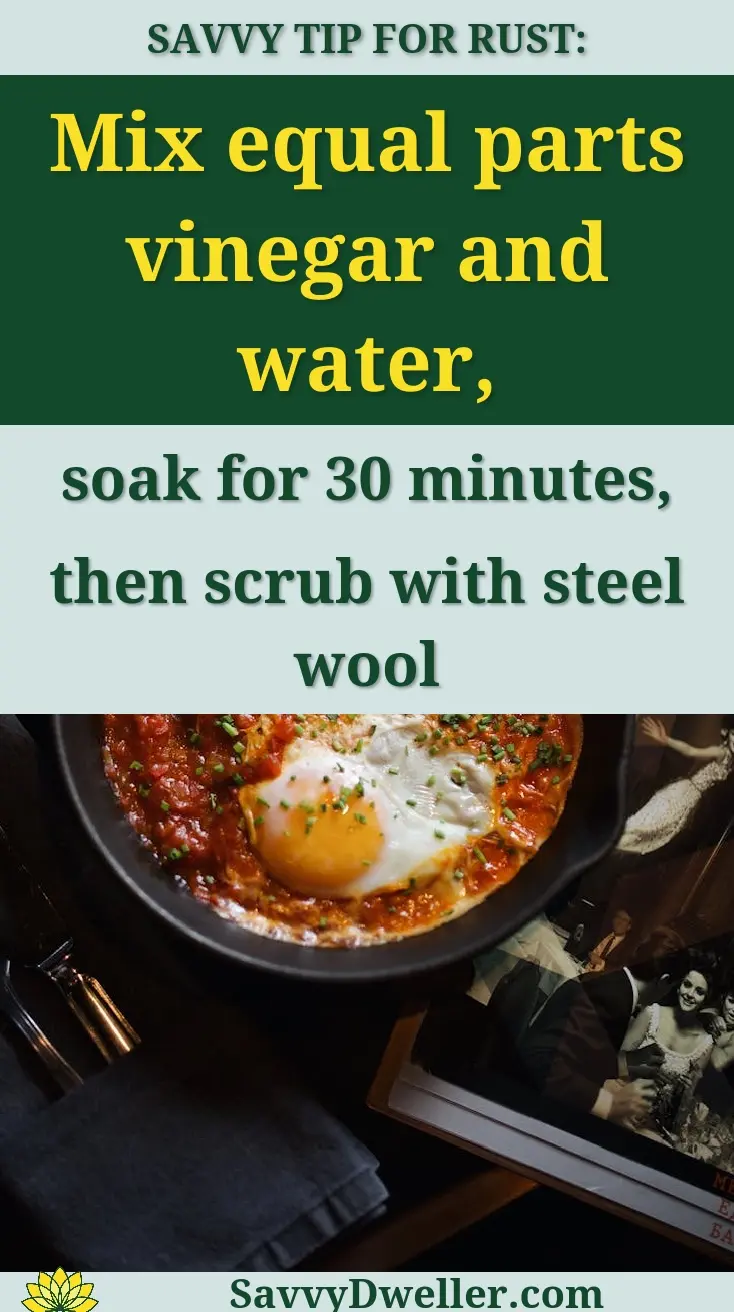 Overhead view of shakshuka in a skillet with bread, water, and lemon slices on a dark table.