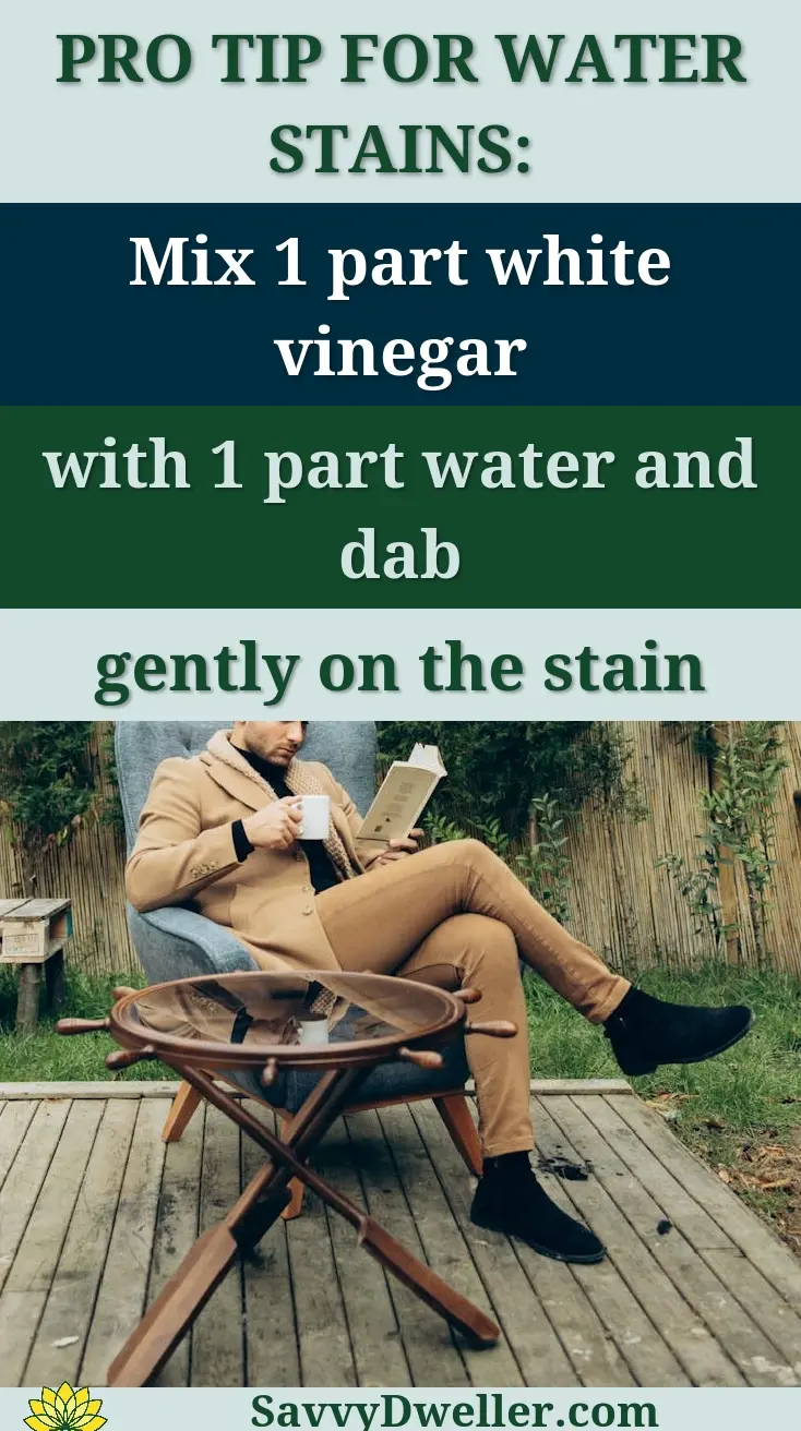 Man in a stylish outfit reads a book while enjoying coffee outdoors in a natural setting.