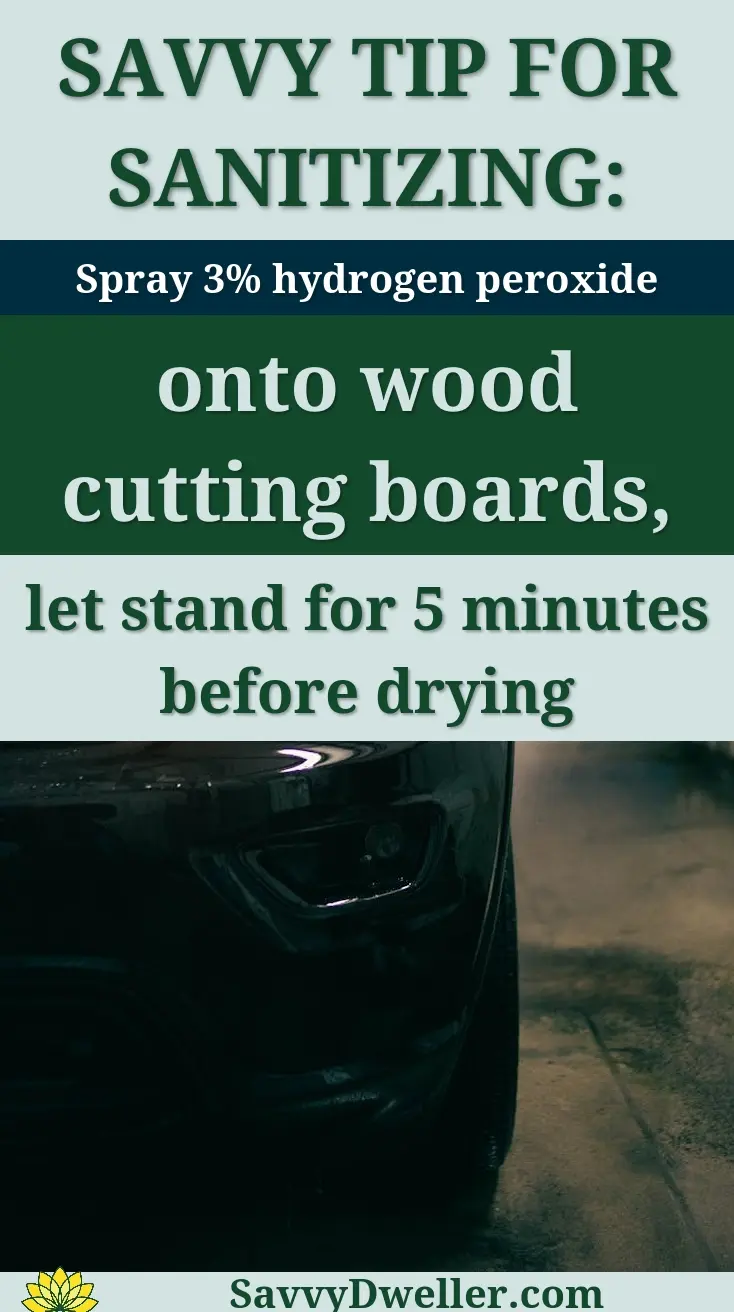 A sleek black car undergoing a wash at night, highlighting the headlight and water reflections.