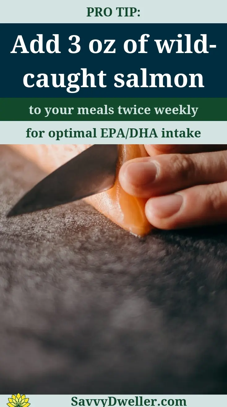 Hand cutting wild-caught salmon for EPA/DHA omega-3 intake.