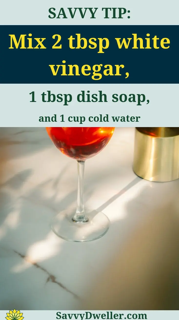 A glass of red wine and a tip for cleaning red wine stains from carpets using white vinegar.