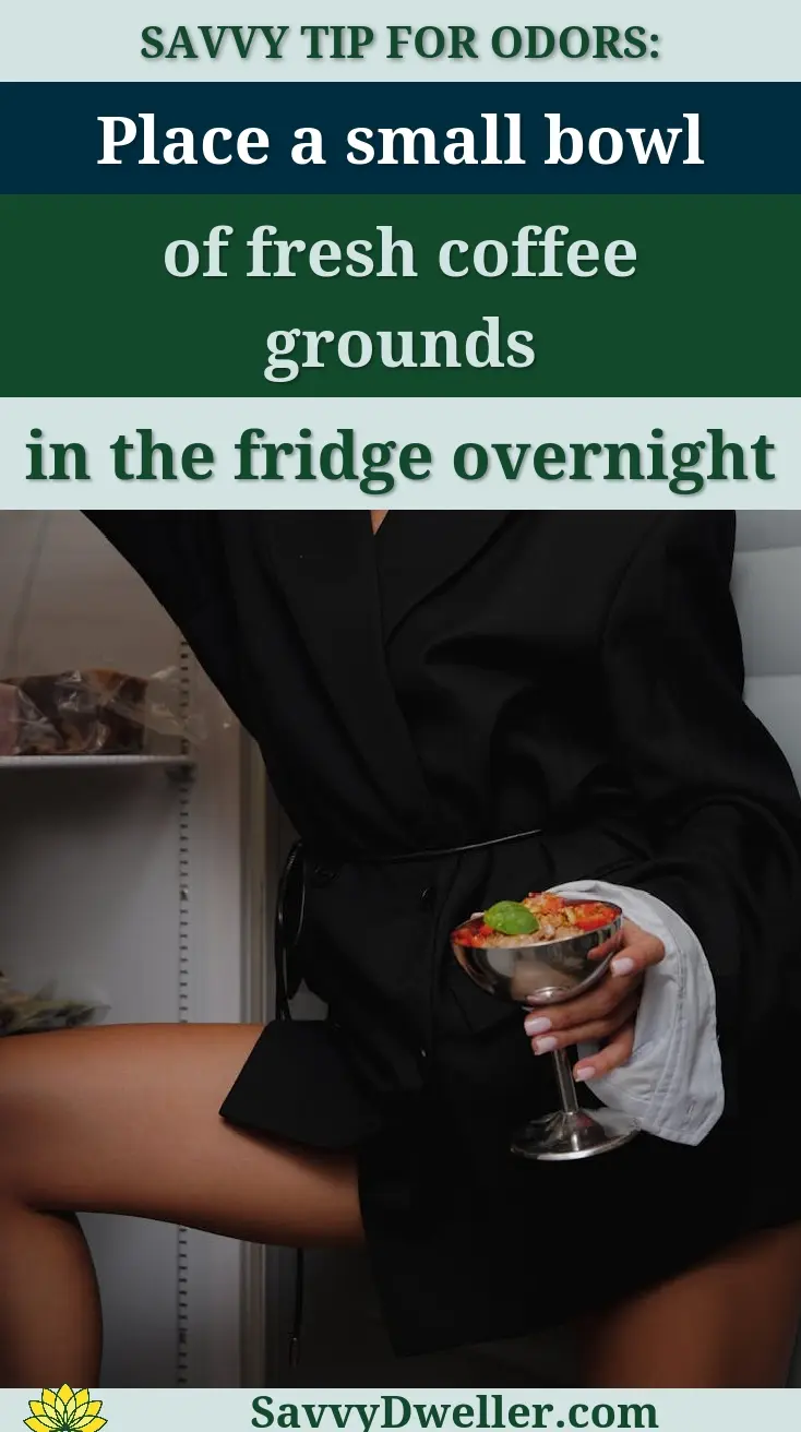 Fashionable woman in black outfit posing with drink in a modern indoor setting.