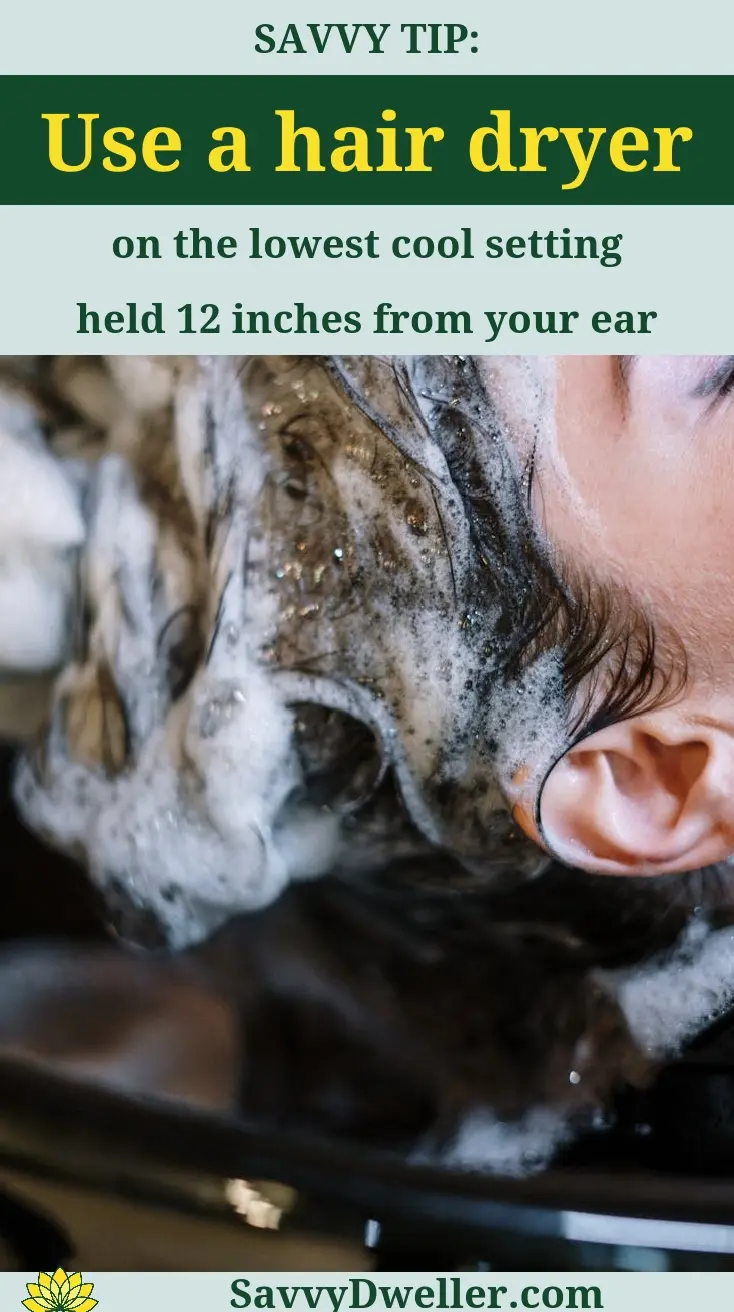 Person using a hair dryer to help remove water from ear for swimmer's ear remedies