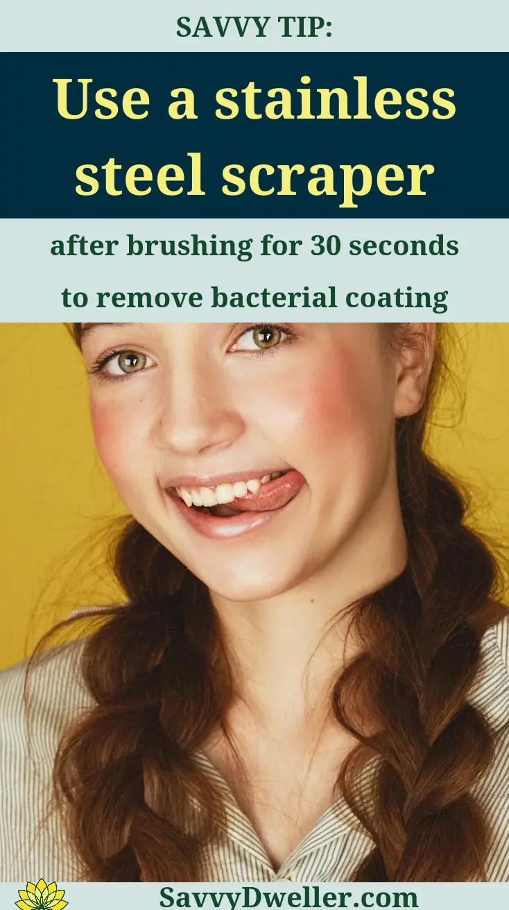 Person using a stainless steel scraper for tongue scraping to improve breath and oral health.